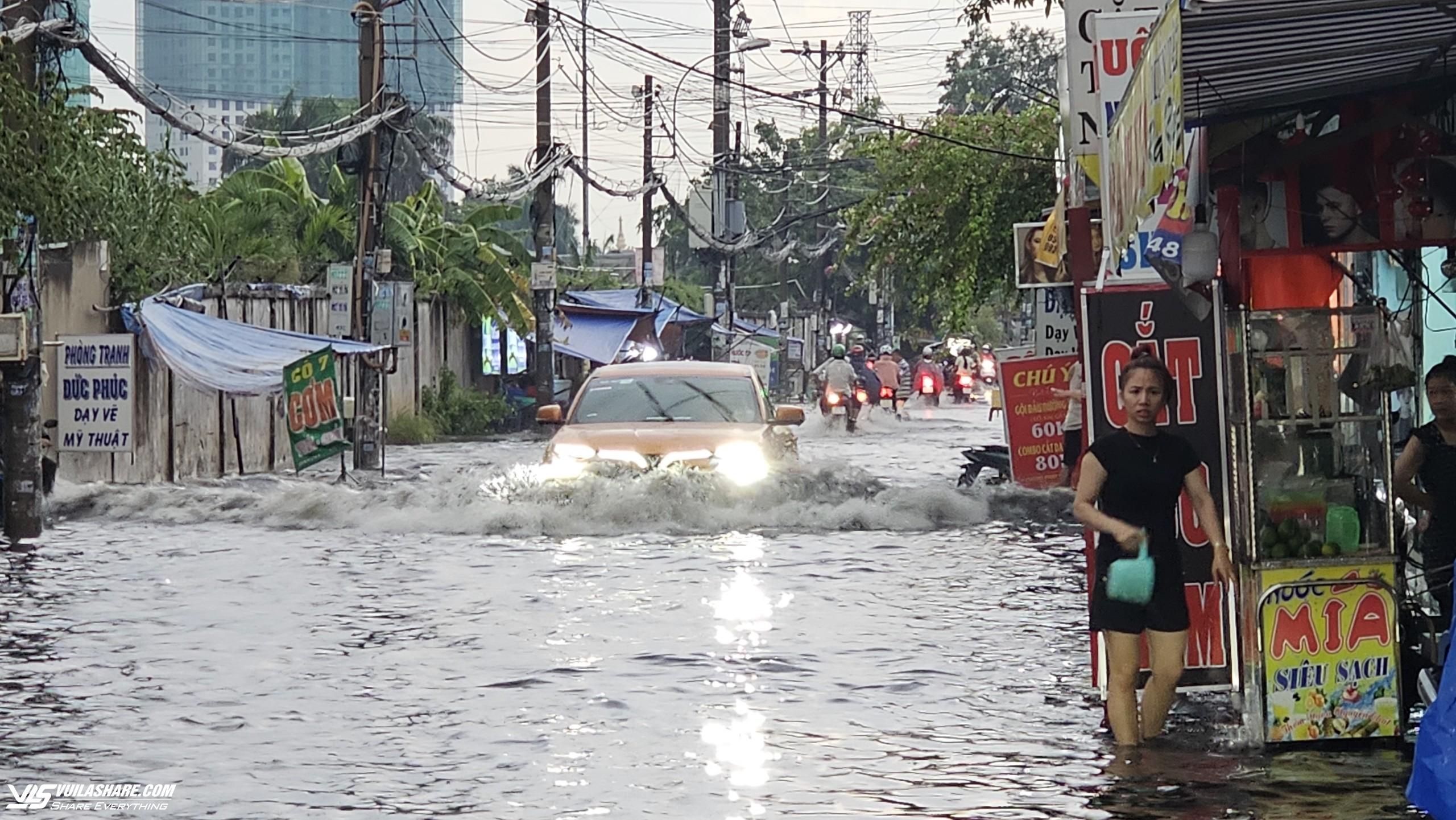 Mưa ngập ở TP.HCM: Bán buôn, đi lại khổ ải trong dòng nước đen gây ngứa- Ảnh 1.