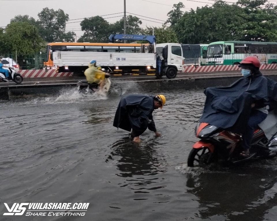 Mưa ngập ở TP.HCM: Bán buôn, đi lại khổ ải trong dòng nước đen gây ngứa- Ảnh 6.